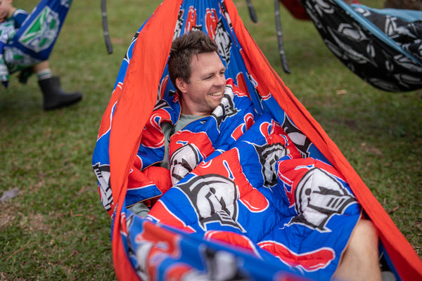 Red and blue Knights NRL recycled hammock with graphic print, displayed in use outdoors with straps visible