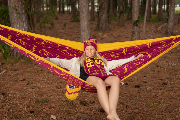 Woman laying back on a Broncos Hammock in the woods