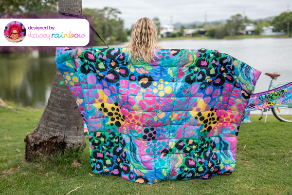 Multicolour leopard and abstract patterned quilted puffy blanket displayed outdoors, designed by Kasey Rainbow.