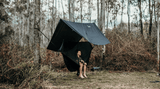 Person snug in nakie Hammock protected by a Nakie Rain tarp in the woods. Nakie - Australia