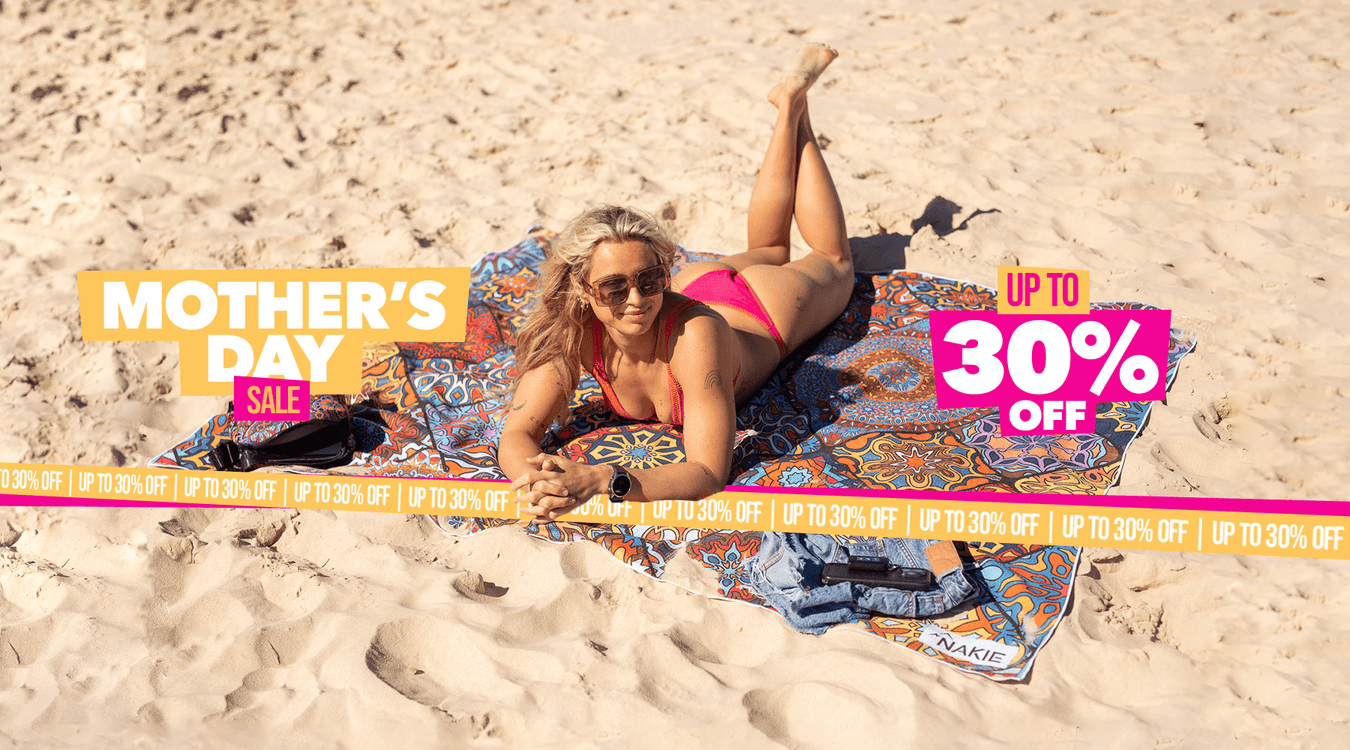 Two women relaxing on a Nakie XL beach towel