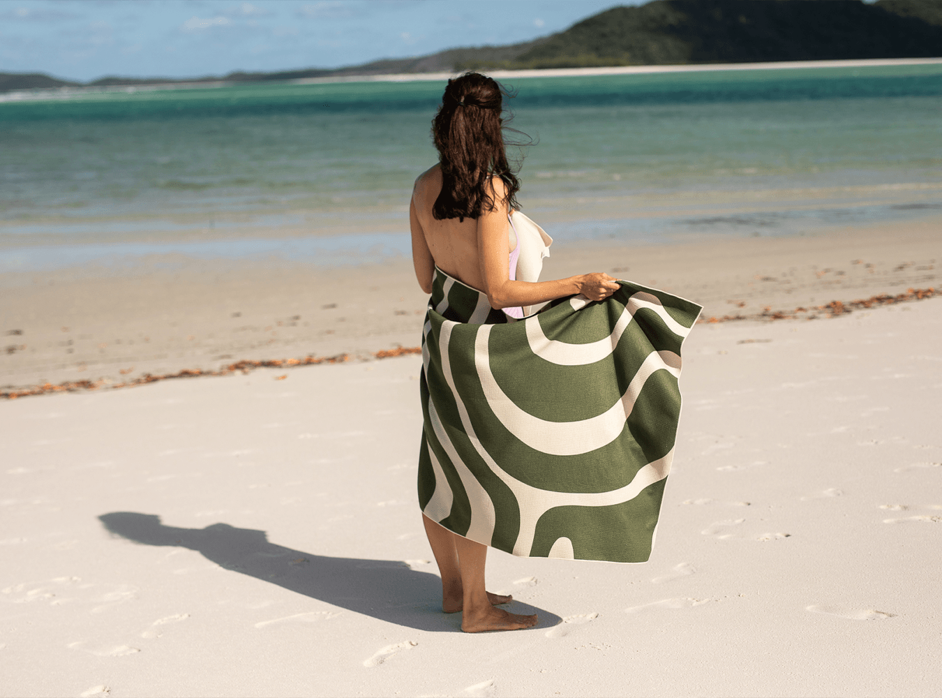 Woman drying herslef on Nakie sand-free recycled beach towel at Moreton Island, Australia