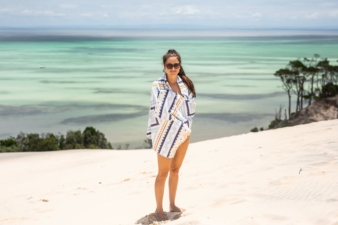 Woman in sand free towel standing on a beautiful beach