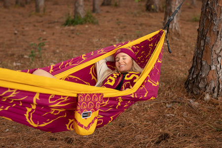 Woman in Broncos gear lying in Broncos eco-friendly hammock