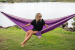 Woman laying in a purple Nakie hammock, highlighting the hammock's portable and easy-to-set-up features preview #13