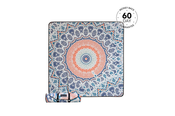 Recycled picnic blanket with coral and navy mandala design, featuring geometric patterns and rolled carrying strap