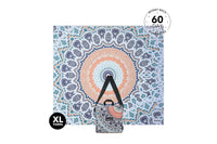 XL beach towel with blue, orange, and cream mandala pattern, shown flat with carrying pouch attached below.
